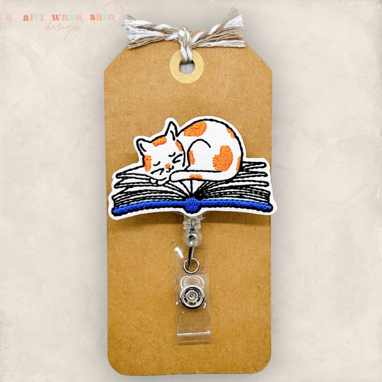 Sleepy Cat on Open Book Badge Topper
