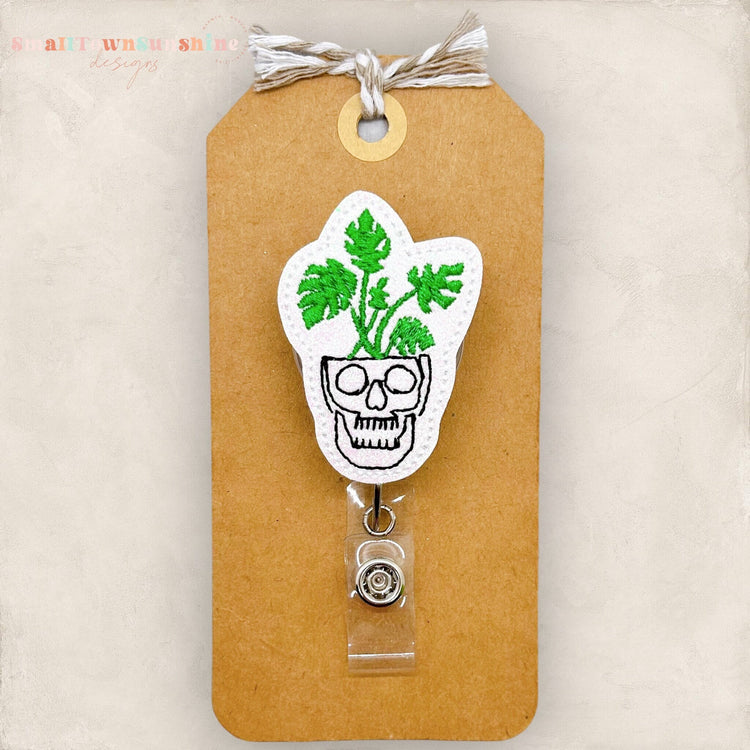 skull shaped planter with green plant badge reel