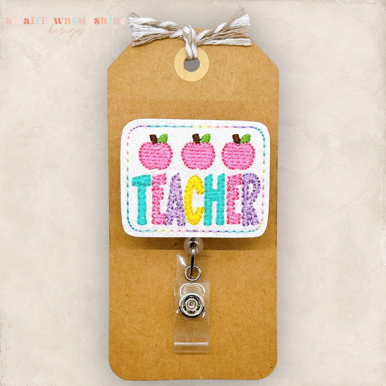 pastel teacher word with pink apples badge reel