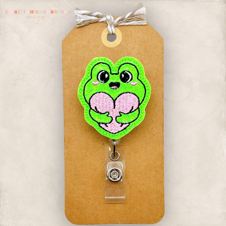 frog hugging heart badge reel