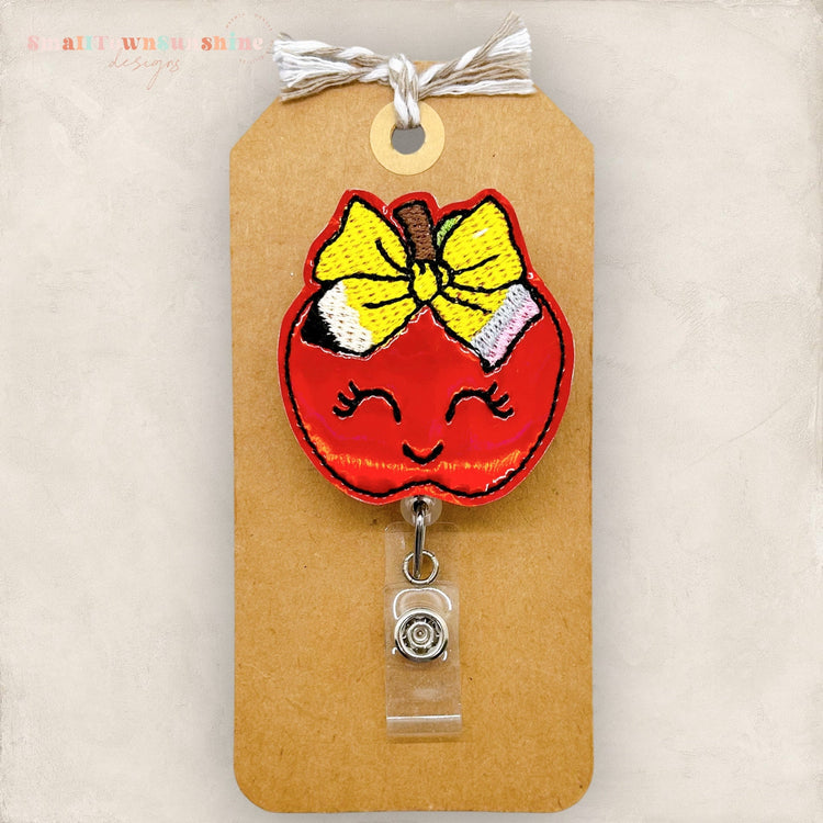 apple with a cute pencil bow badge reel