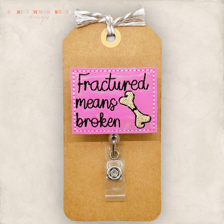 fractured means broken with a cracked bone badge reel