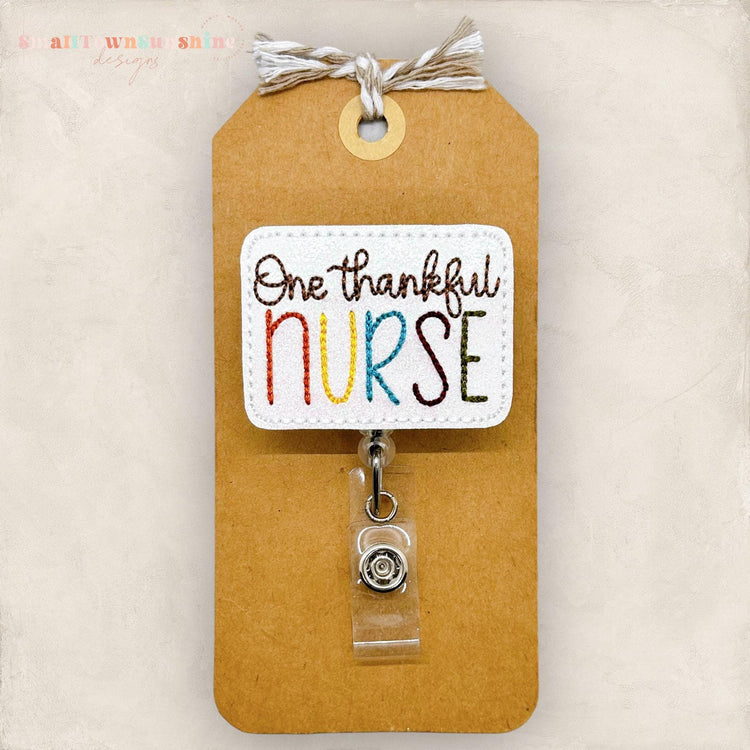 one thankful nurse embroidered on white glitter vinyl for a badge reel