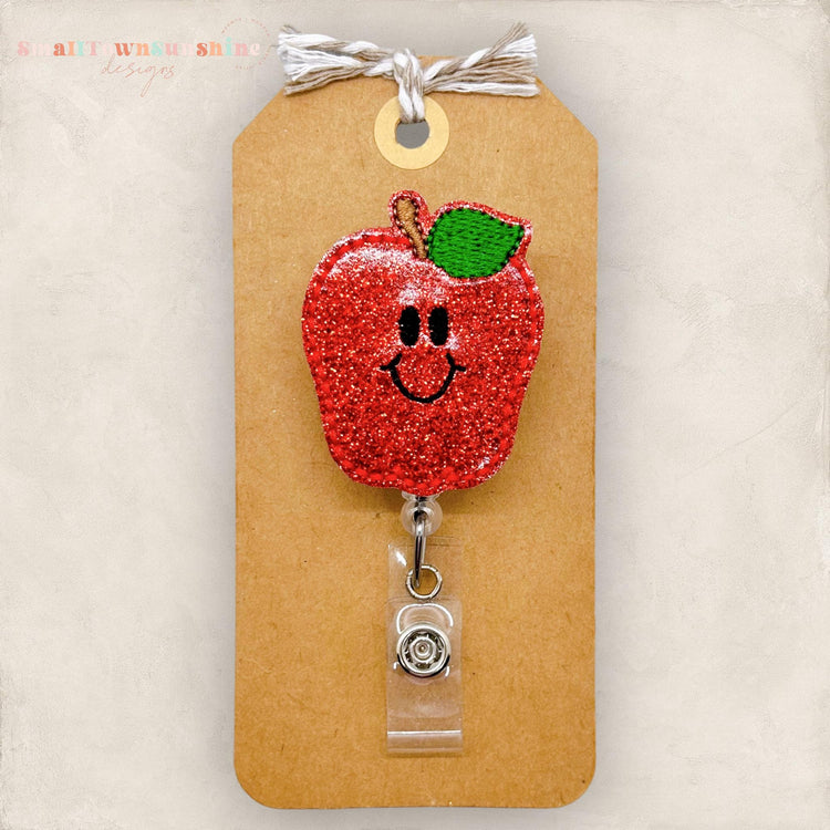 cute glittery apple with a happy face badge reel