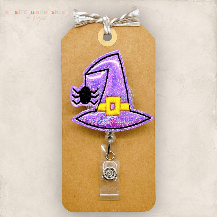 purple witch hat with spider hanging halloween badge reel