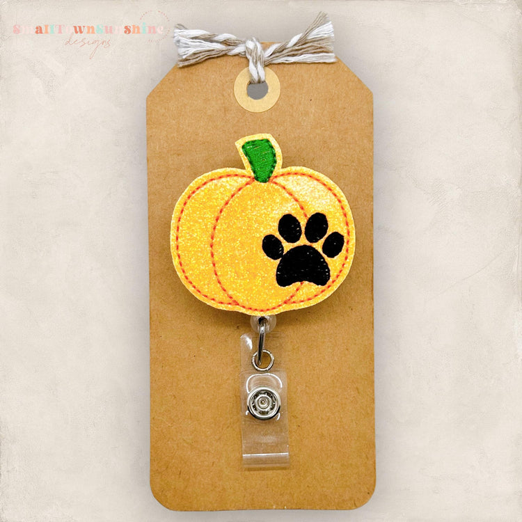 orange pumpkin with a paw print badge reel