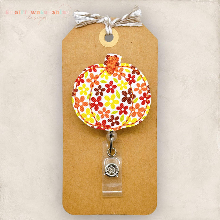 embroidered pumpkin with fall colored daisy print for badge reels