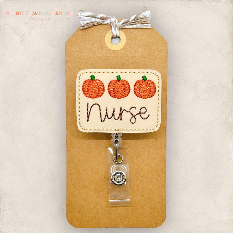 3 embroidered pumpkins with the word nurse for a badge reel