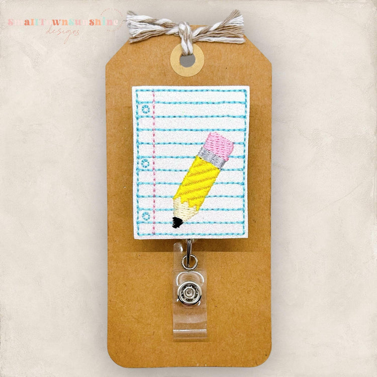 lined paper with pencil embroidered badge reel