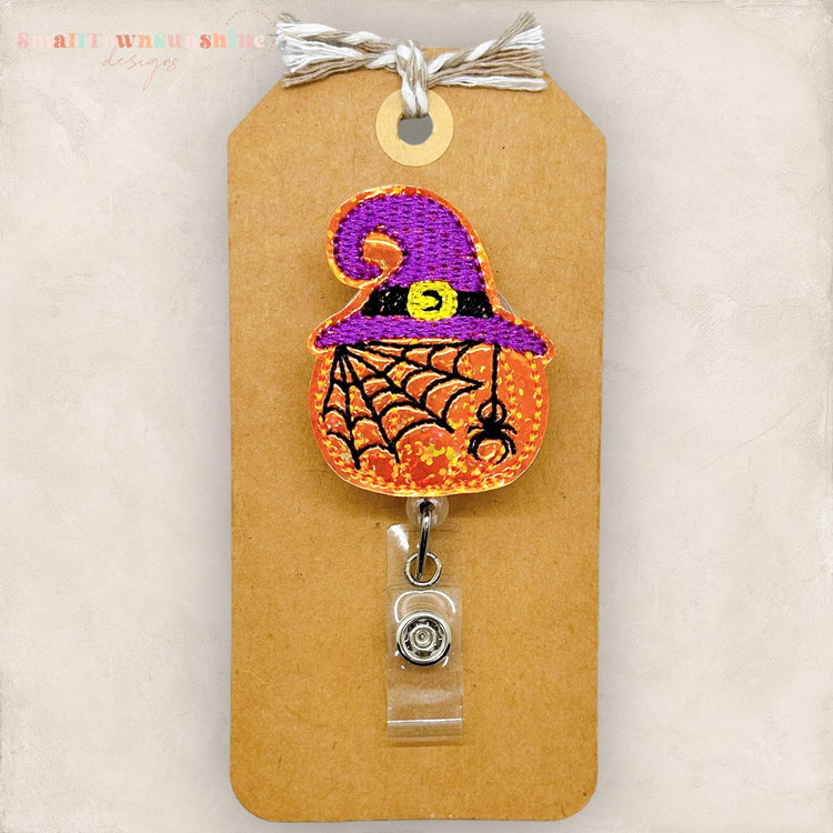 pumpkin with spider and spiderweb with a purple witch hat embroidered badge topper