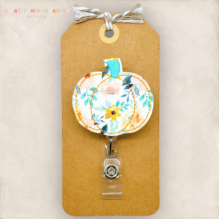 embroidered pumpkin with a pastel floral print badge reel topper