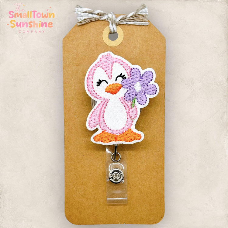 embroidered pink penguin with purple daisy badge reel topper