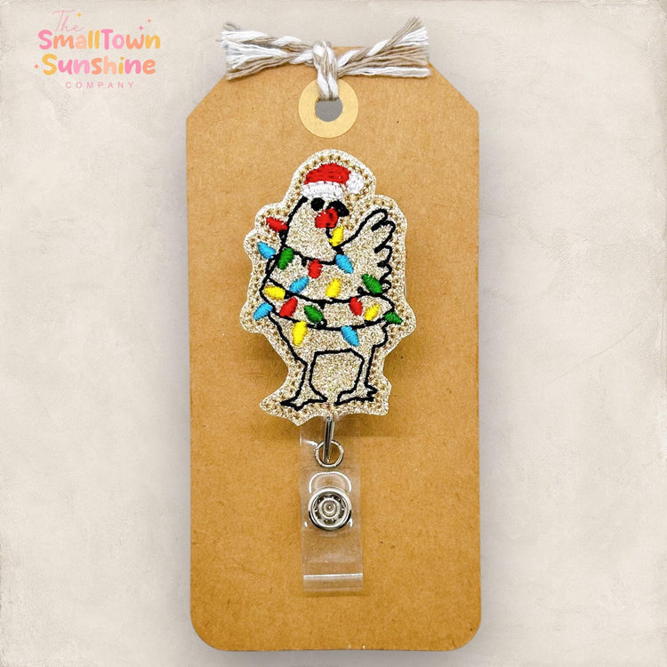 embroidered tan christmas chicken with lights and a santa hat badge reel topper