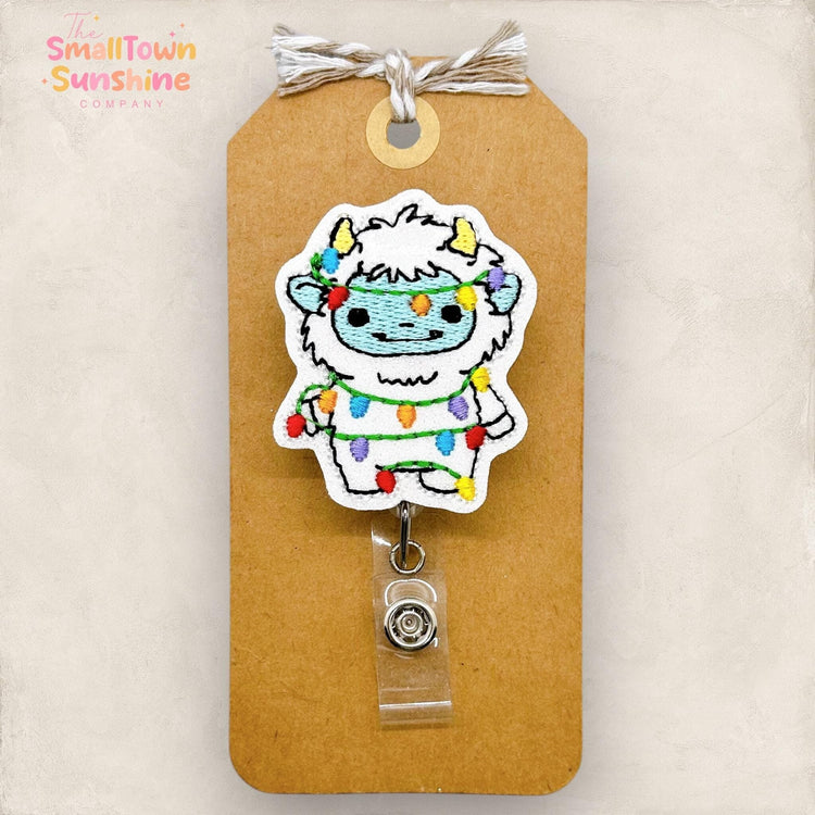 abominable snowman wrapped in christmas lights badge reel topper