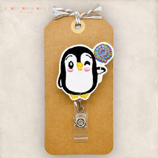 A penguin badge with a colorful spiral design attached to it.