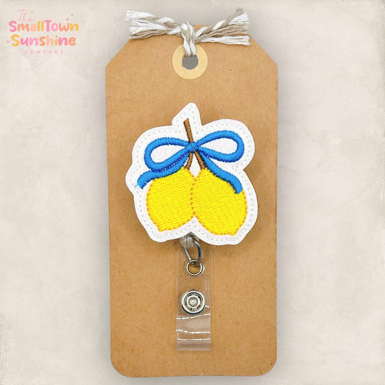 Badge reel with two yellow lemons and blue coquette bow