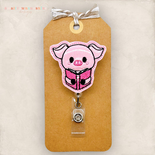 pig hugging book badge reel