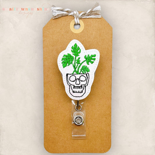 skull shaped planter with green plant badge reel