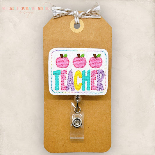 pastel teacher word with pink apples badge reel