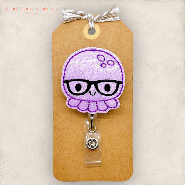 purple octopus with black glasses badge reel