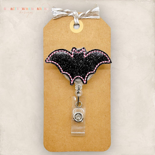 glittery black bat with pink edges badge reel