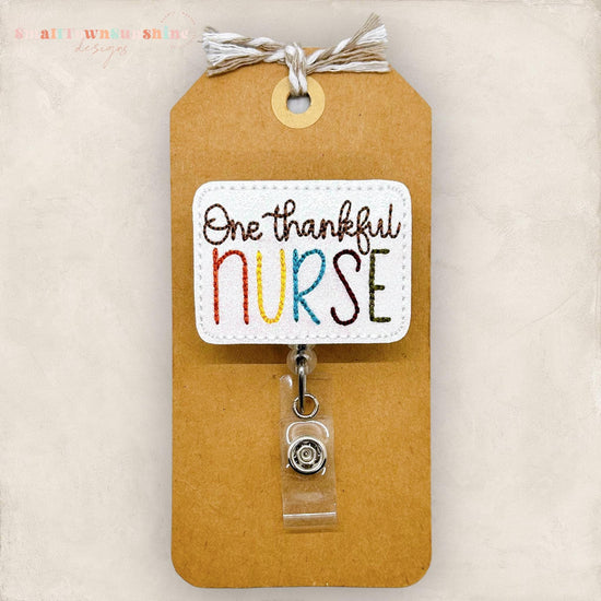 one thankful nurse embroidered on white glitter vinyl for a badge reel