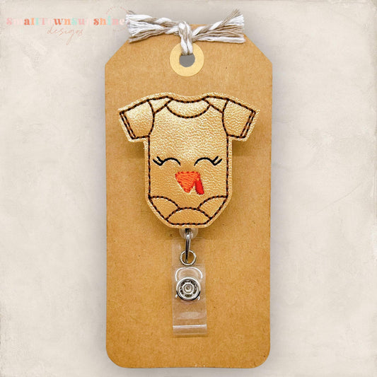brown baby bodysuit with a turkey face embroidered for a badge reel