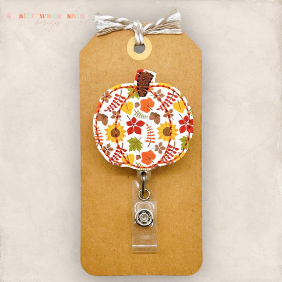 embroidered pumpkin with a fall leaf print for badge reels