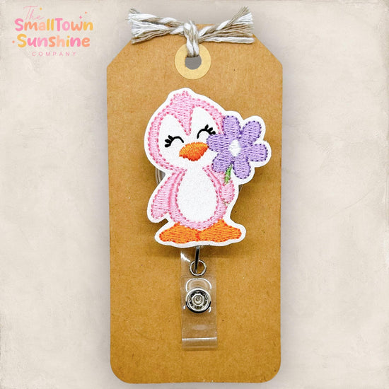 embroidered pink penguin with purple daisy badge reel topper