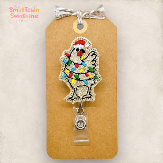 embroidered tan christmas chicken with lights and a santa hat badge reel topper